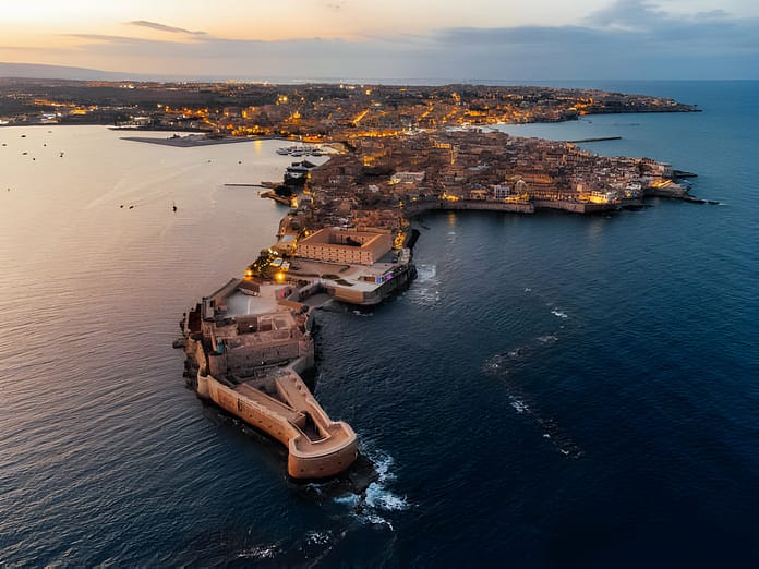 Aerial view of Ortigia Island and Siracusa city at sunset. Landmark in Sicily, Italy.